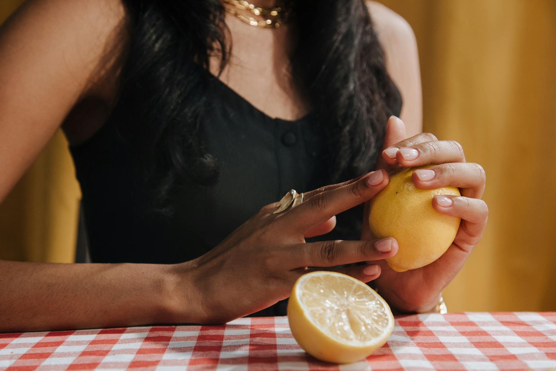 Blue clitoral vibrator surrounded by fresh citrus and flowers on a bright yellow background