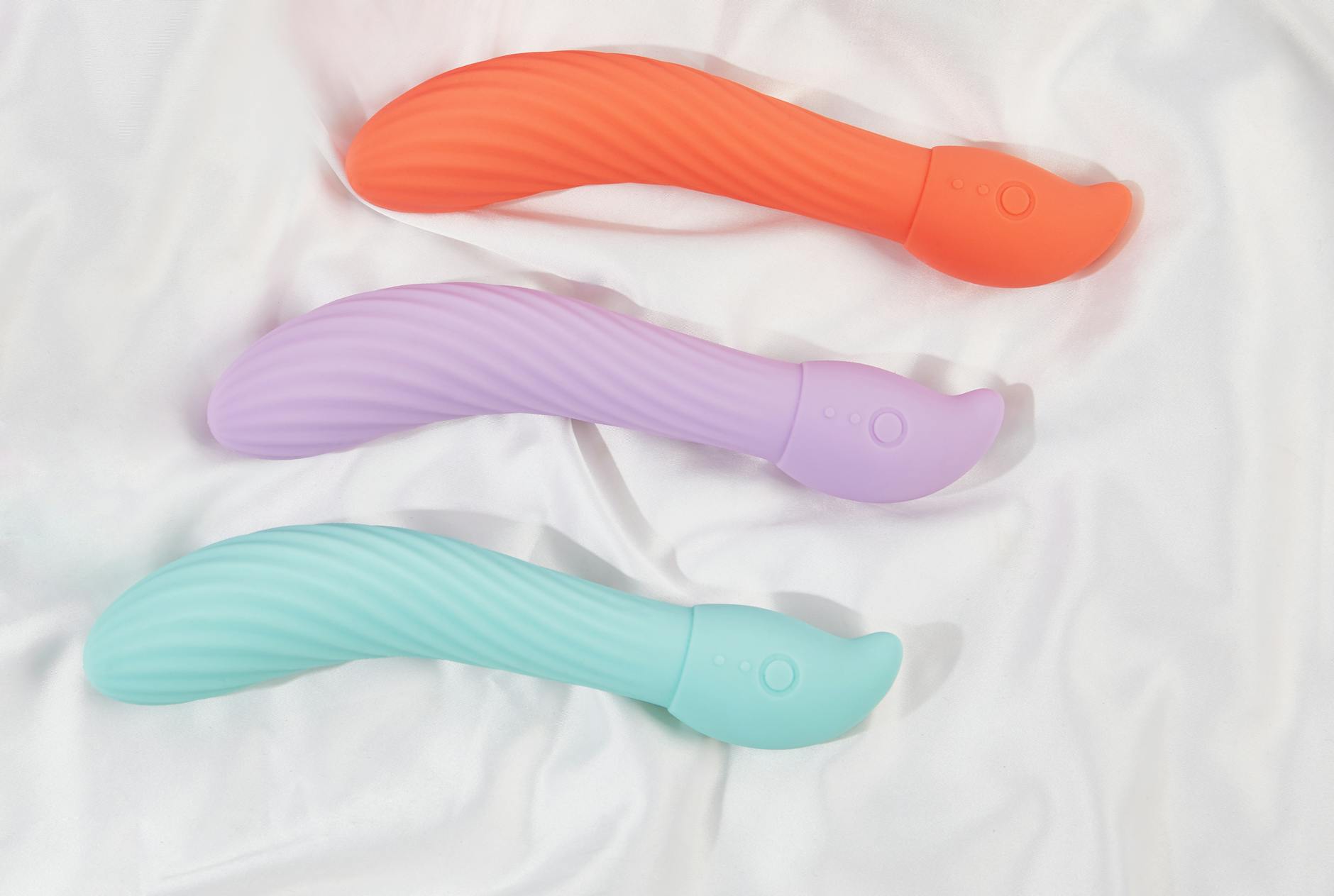 A silicone vibrator held in hand against a purple background, symbolizing reconnection to pleasure and self-love.