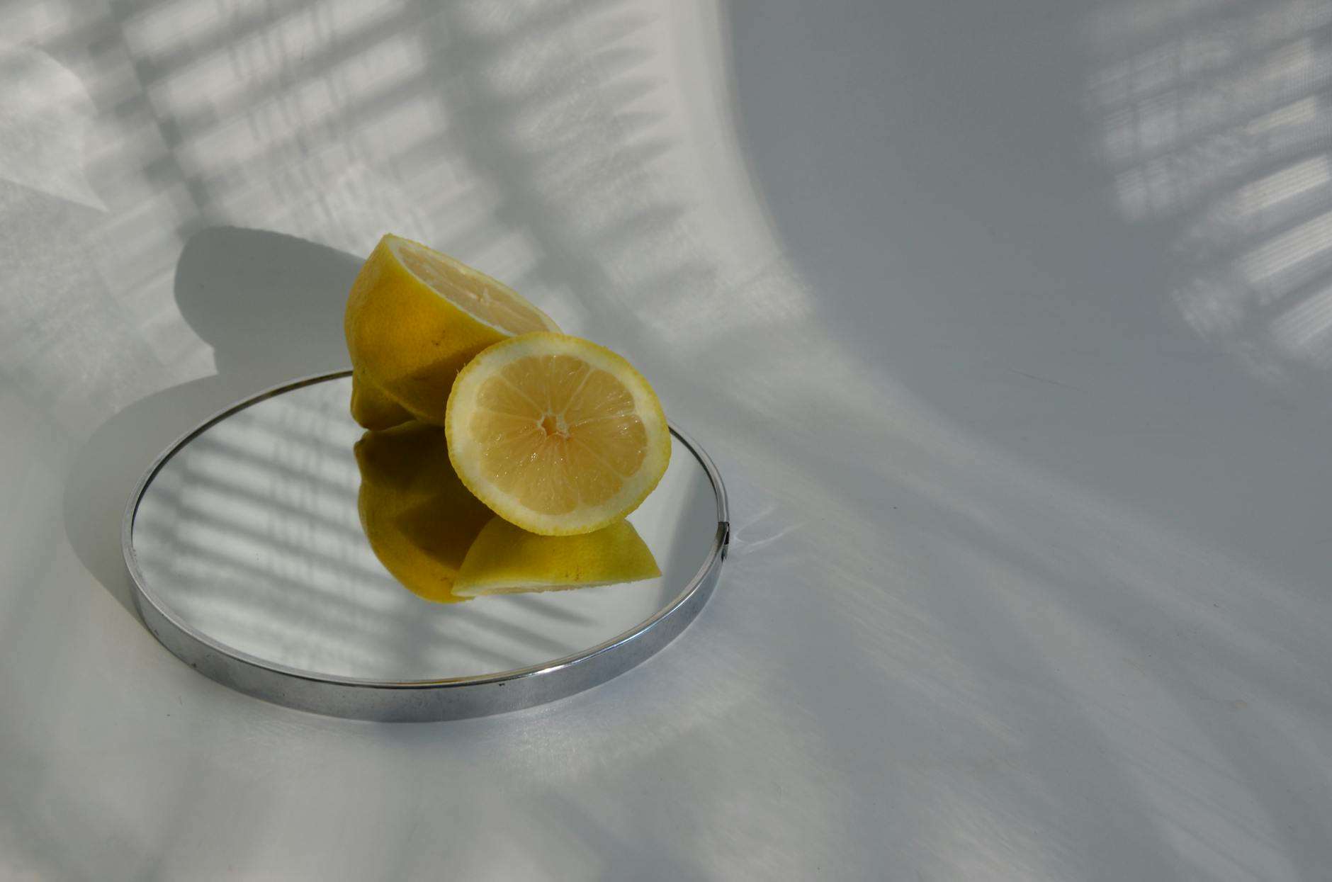 A hand holding a lemon on a soft pink background, symbolizing fresh beginnings and self-discovery
