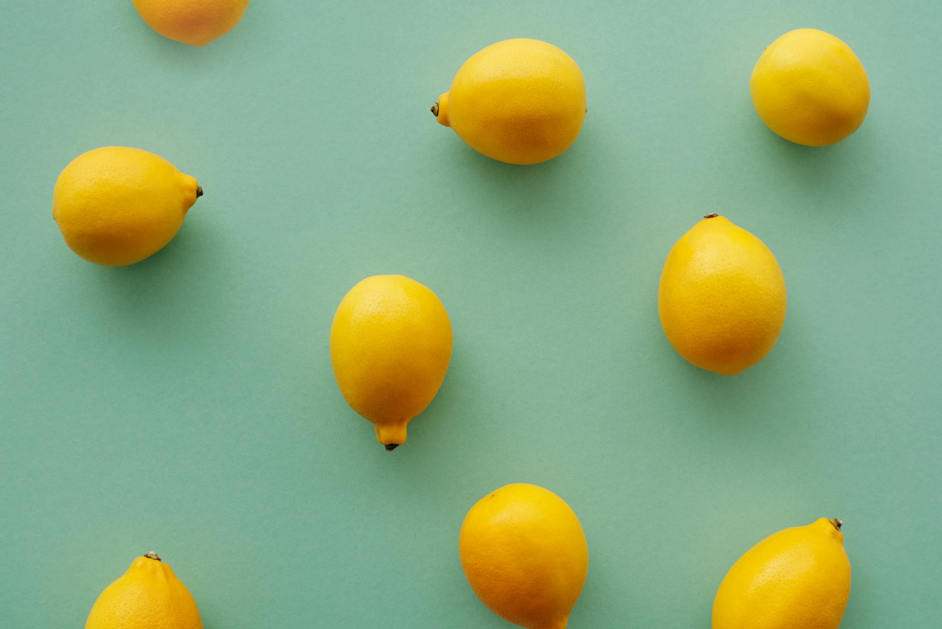 Bright yellow lemons arranged on a pastel green background, symbolizing the varied and unpredictable nature of desire cycles.