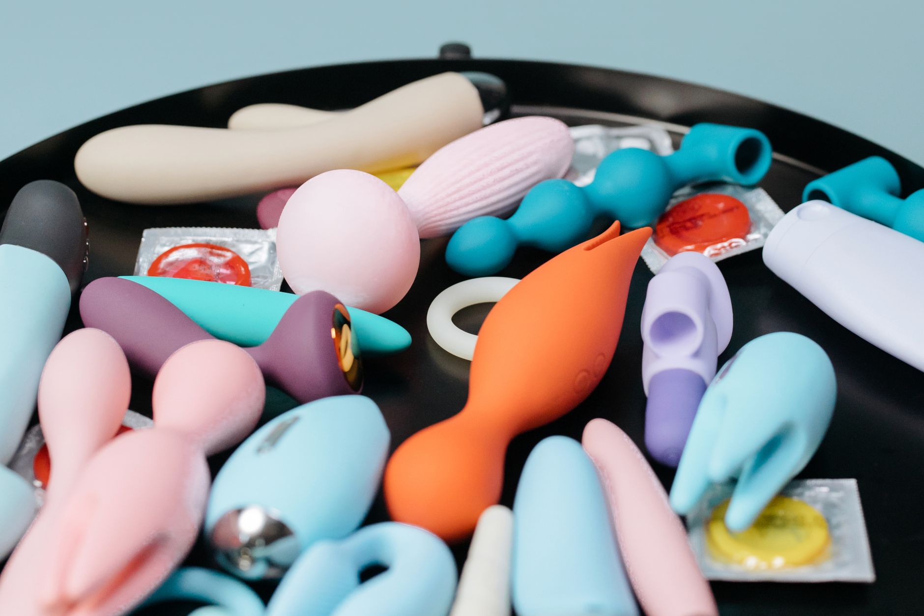 Collection of colorful clitoral vibrators and lemon suction toys arranged on a dark surface