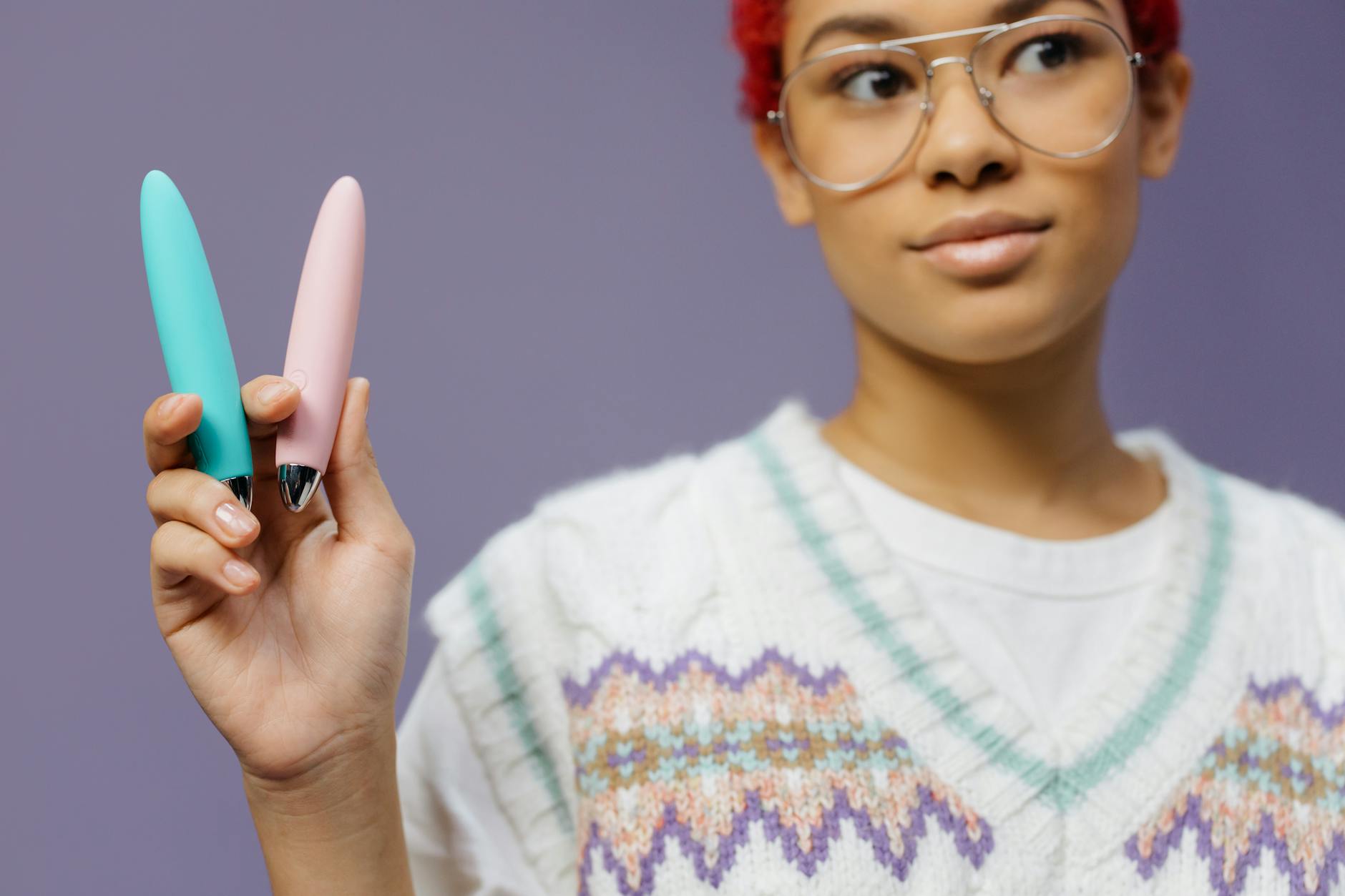 A young couple standing together indoors, holding a vibrator, symbolizing modern intimacy and communication